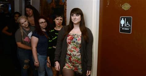 Line For Bathroom Silently Glares At Woman In Romper