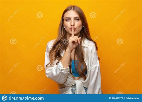 Pretty Young Woman Holding Finger On Lips And Showing Silence Sign On