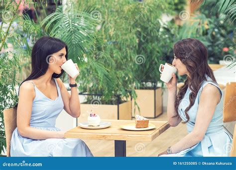 Two Young Women Are Drinking Coffee Together Outside Stock Image Image Of Looking Friends