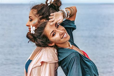 Two Beautiful Stylish Young Women Twin Sisters Having Fun On The Beach