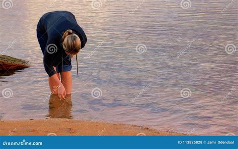 Blonde Girl Picking Up Shells From A Pond Stock Photo Image Of Girl Still