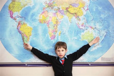 Premium Photo The Child Stands At The Geographical Map Of The World