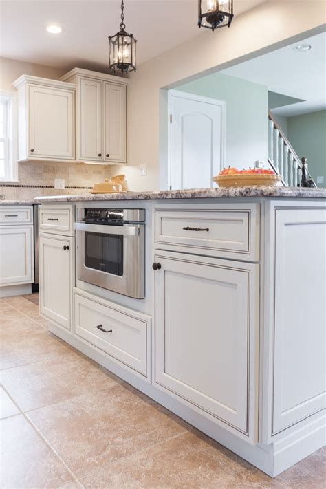 A Kitchen With White Cabinets And An Oven