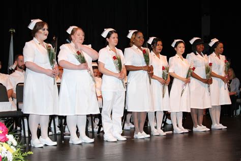 A Group Of Women Standing On Top Of A Stage Next To Each Other Holding Flowers