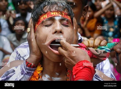 A Hindu Devotee Gets His Cheeks Pierced As He Takes Part In An Annual Religious Procession
