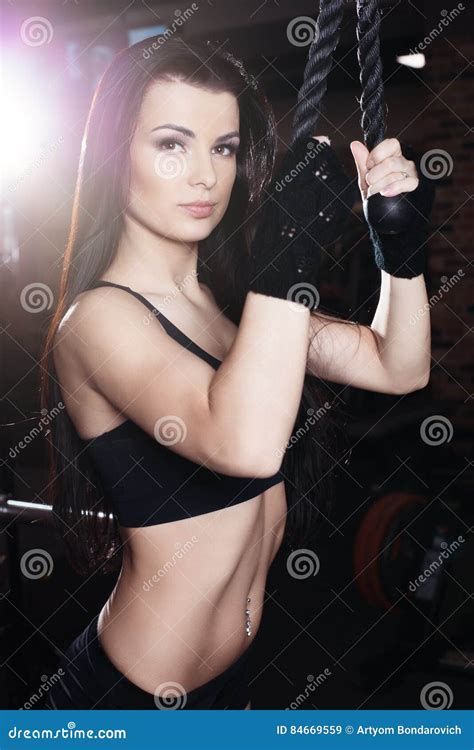Muscular Brunette Fitness Girl Doing Exercises In The Gym Fitness Girl Lifting Weights On A