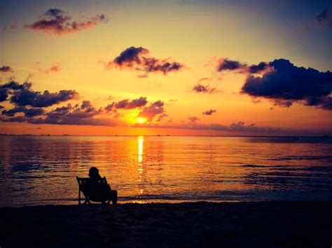 Premium Photo Silhouette Of Man Relaxing On The Beach At Sunset Time