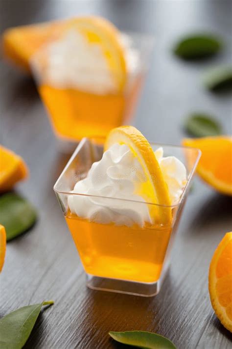 Orange Jelly In A Cup With Whipped Cream And Orange Sliced On Bl Stock