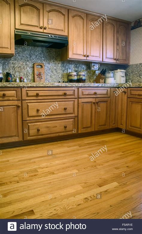 Oak kitchen cabinets are popular in traditional kitchen designs. Kitchen with oak cabinets & wood floor and granite countertops and Stock Photo: 89362714 - Alamy