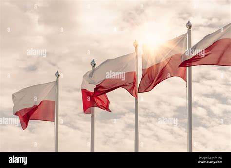 Polish National Flags Flutter In The Wind On A Cloudy Sky Background