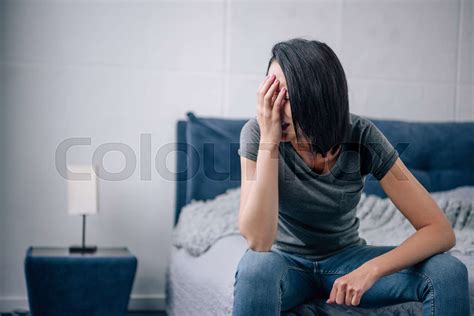 Depressed Woman Sitting On Bed At Home And Crying Stock Image Colourbox