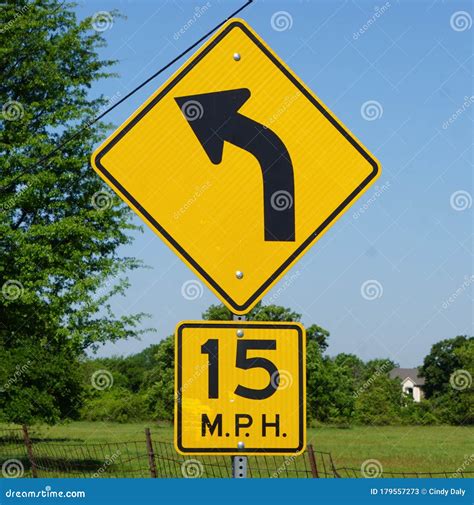 A Curve Road Sign With A 15 Mph Speed Posted On A Country Road In Texas