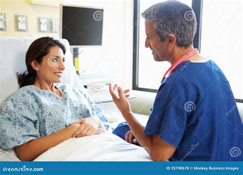 Male Nurse Talking With Female Patient In Hospital Room Stock Photo