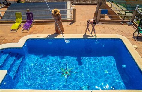 premium photo two female friends and lesbian couple cleaning a swimming pool together dressed