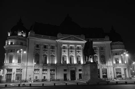 A Large Building That Has A Statue In Front Of It At Night With Lights On