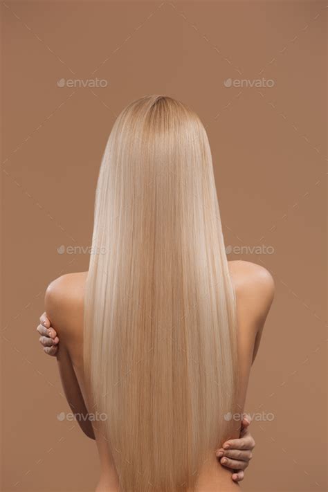 Back View Of Naked Woman With Long Blond Hair Isolated On Brown Haircare Concept Stock Photo