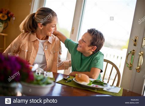 Madre E Hijo Sentados En La Mesa De Comedor Con Sus Brazos Alrededor De