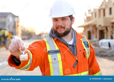 Engineer Giving Keys From New House On Construction Site Stock Photo