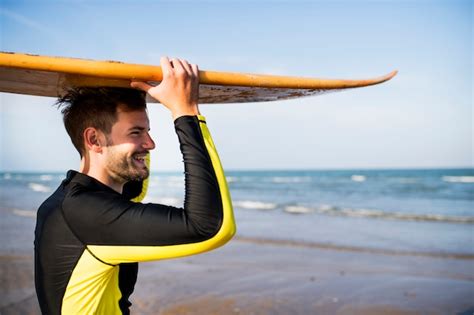 Hombre En La Playa Con Su Tabla De Surf Foto Premium