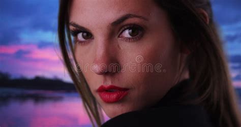 close up of beautiful lady looking over shoulder with beach sunset in background stock footage