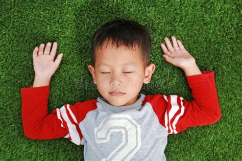 Peaceful Asian Little Boy Close Eyes And Lying Down On Green Lawn Kid