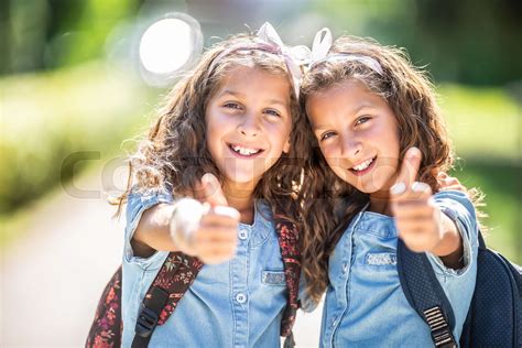 Twin Sisters Go Back To School And Showing Thumbs Up Stock Image