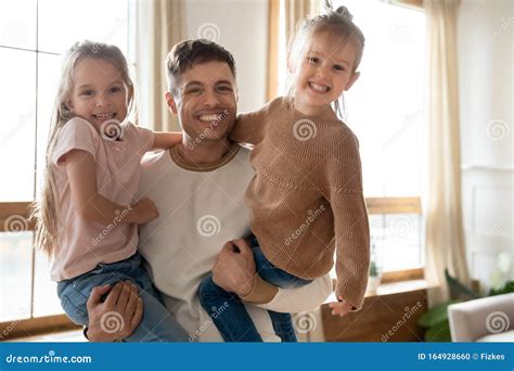 Caring Smiling Single Dad Holding Cute Daughters Look At Camera Stock
