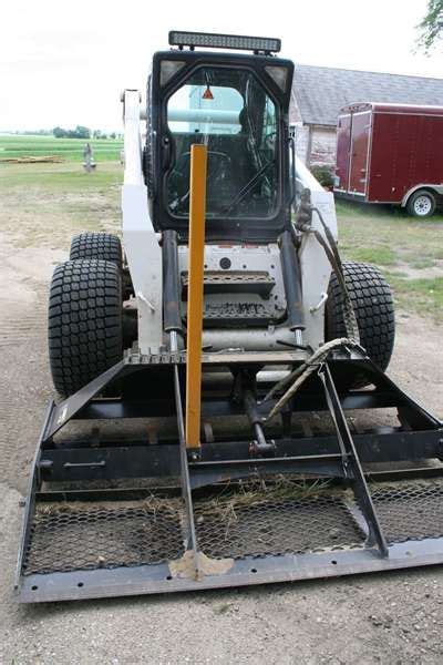 The Front End Of A Skid Steer On A Dirt Road