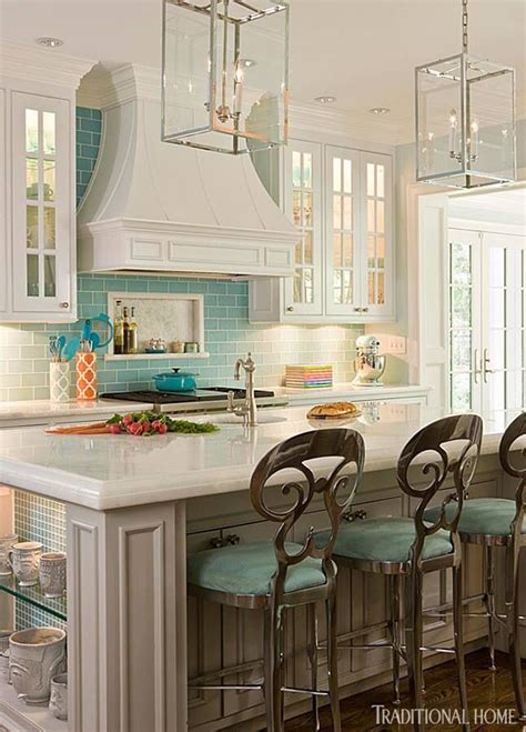 A Kitchen With White Cabinets And Blue Backsplashes An Island With