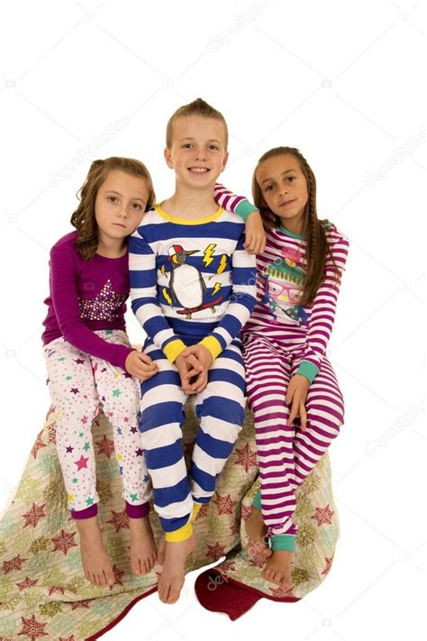 Three Kids In Colorful Pajamas Sitting On A Blanket Stock Photo By