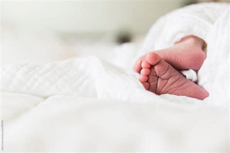 Tiny Infants Feet On A White Bed By Stocksy Contributor Holly Clark Stocksy