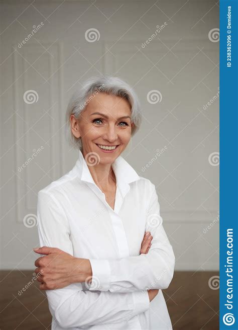 Close Up Portrait Of Beautiful Older Woman Standing By Wall Stock Photo