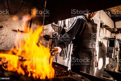 Blacksmith Heating Up Iron In The Forge Fire Stock Photo Download