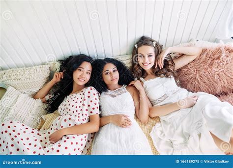 Beautiful Multi Ethnic Girls Relax Together And Lying On Bed Inside The Camper Van Stock Image
