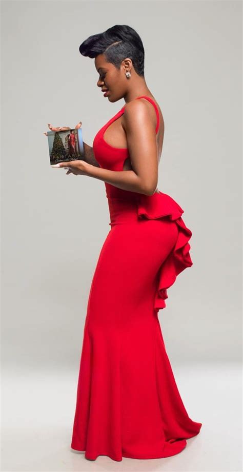 A Woman In A Red Dress Is Holding A Book And Looking Down At Her Face