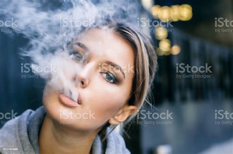 Young Woman Smoking Electronic Cigarette Stock Photo