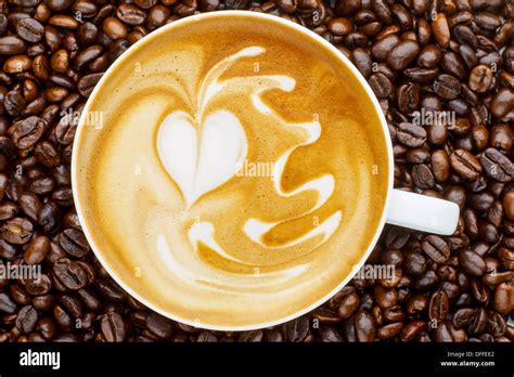 Latte art, coffee in coffee beans background Stock Photo - Alamy