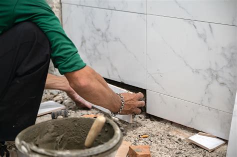 Foto De Azulejo Masculino Usando Espátula Colocando Azulejo De Mármore