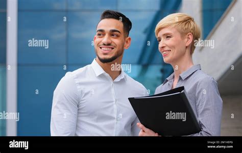 Multiracial Couple Two Business Colleagues Two Architects Man And Caucasian Woman Holding Folder