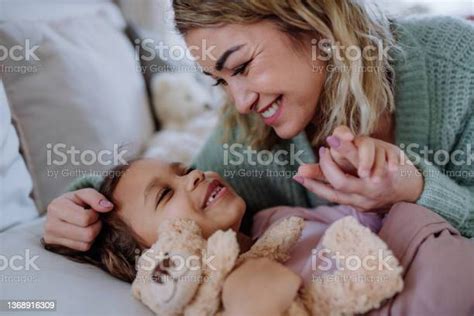 Happy Mother Stroking Her Little Daughter When Looking At Each Other On