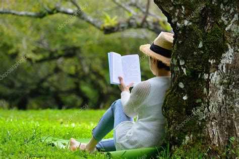 Woman Sitting Under A Tree Reading A Book In The Park — Stock Photo