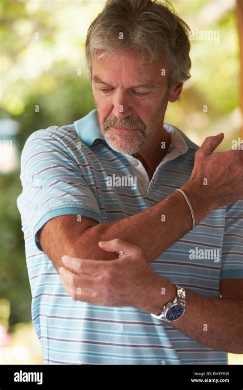 Mature Man Suffering From Painful Elbow At Home Stock Photo Alamy