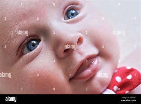 Infant Baby Boy Closeup Detail On Face With Bright Blue Eyes Stock