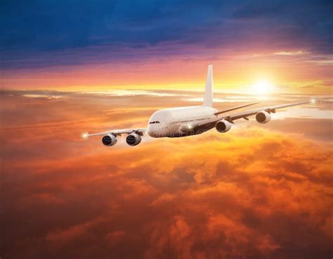 Airplane Flying Above Clouds In Dramatic Sunset Stock Photo Image Of