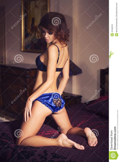 Woman With Curly Hairstyle Standing On Her Knees On The Luxury Bed
