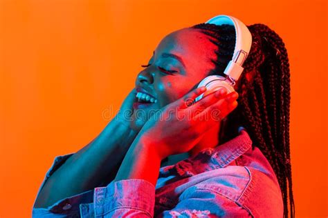 Neon Portrait Of Young Black Woman Listen To Music In Headphones Stock