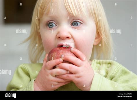 Young Girl Taking A Big Bite Out Of An Apple Stock Photo Alamy