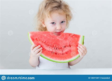 Cute Little Baby Girl Eating Watermelon Slice On Light