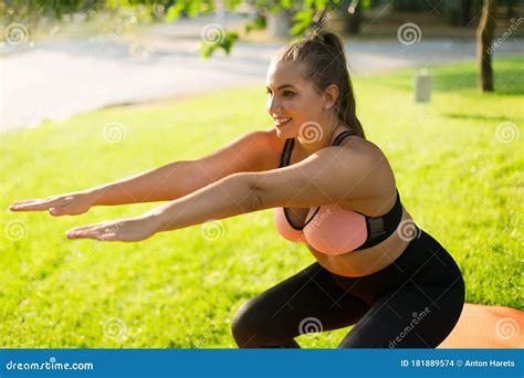 attractive smiling plus size girl in sporty top and leggings doing sport exercises on yoga mat