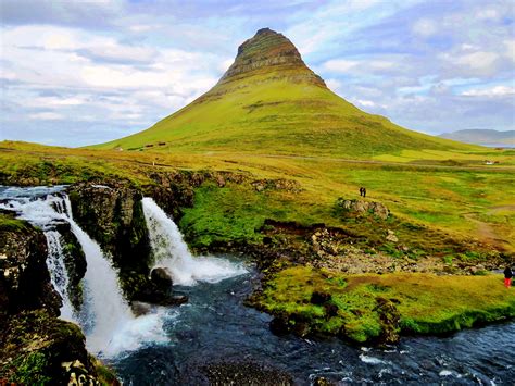 Time-lapse photo of water falls near to perfect cone mountain, iceland